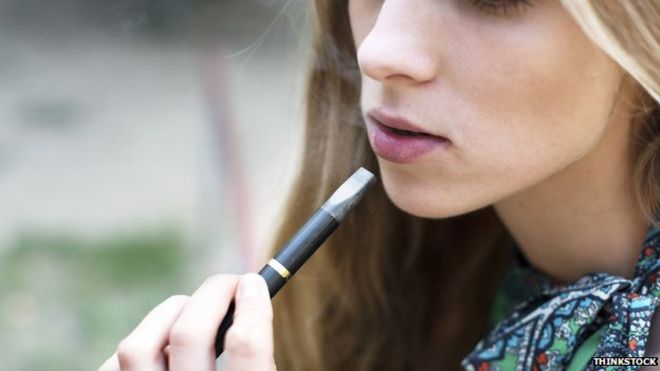 alt="teen girl using e-cigarette"