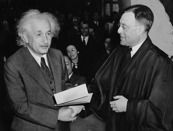 Albert Einstein shaking hands with another man