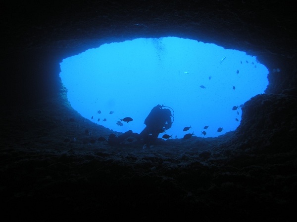 a man scuba diving into an underwater cave