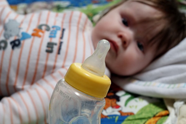 Baby staring at baby bottle