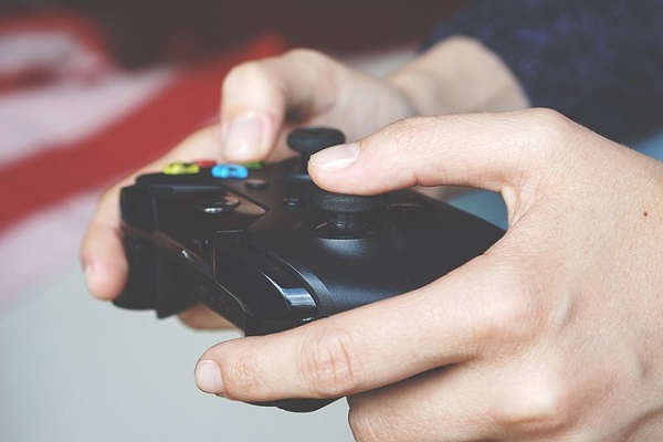 Hands of a young man holding a PS4 controller