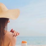 Woman applying sunscreen at the beach